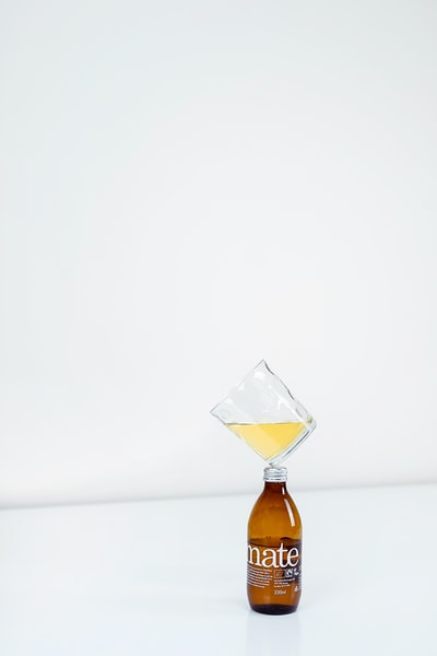 1/4完整清晰的饮用玻璃杯上的琥珀瓶
